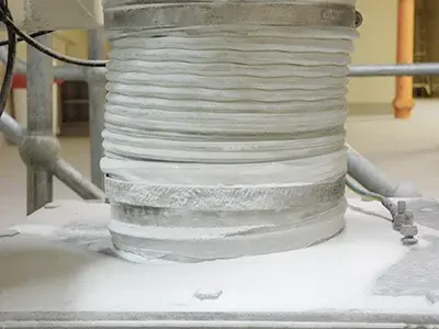 Powder leaking through a hose-clamped flexible connection